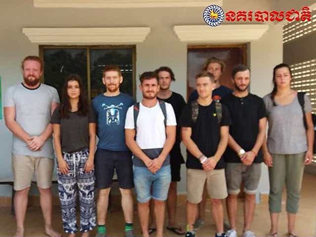 A group of foreigners stand after they were arrested for "dancing pornographically" at a party in Siem Reap town near Cambodia's famed Angkor Wat temple complex