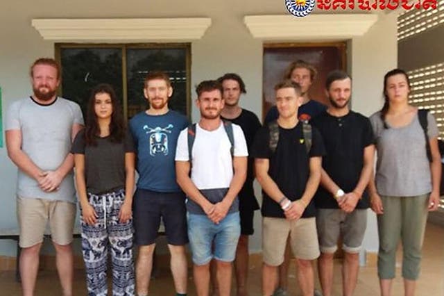 A group of foreigners stand after they were arrested for "dancing pornographically" at a party in Siem Reap town near Cambodia's famed Angkor Wat temple complex