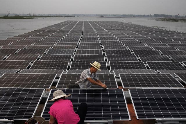 Workers prepare panels on the Chinese solar farm