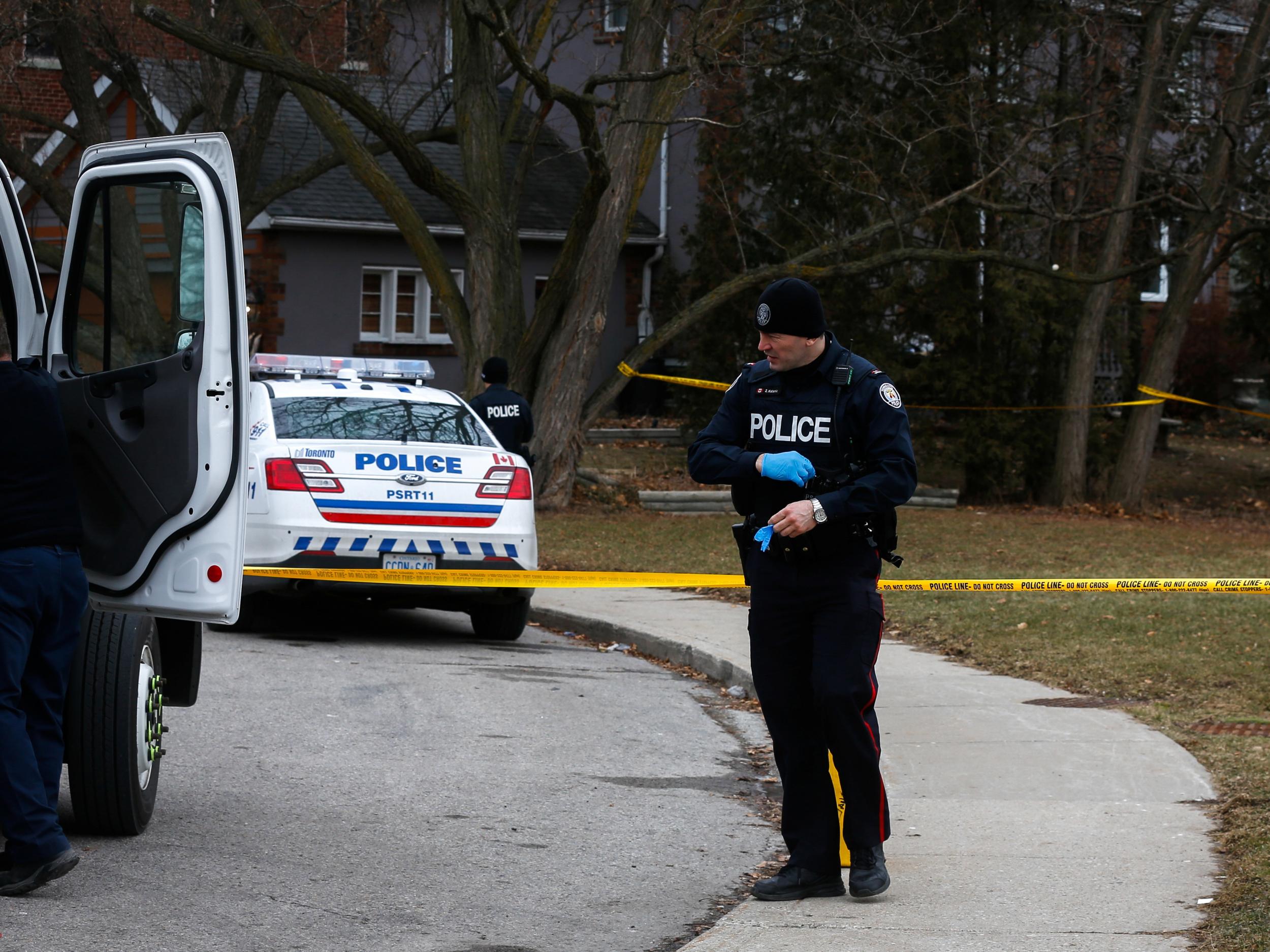 Police officers guard the grounds of a house they searched after a landscaper was accused of murdering five people and putting their dead bodies in large planters on his clients' properties in Toronto