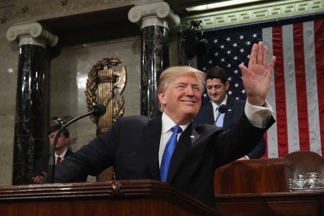 US President Donald Trump waves as he arrives during the State of the Union address in the chamber of the US House of Representatives