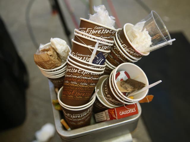 Used coffee cups and discarded cigarette boxes left by members of the media lie piled up in a garbage can outside the headquarters of the German Social Democrats