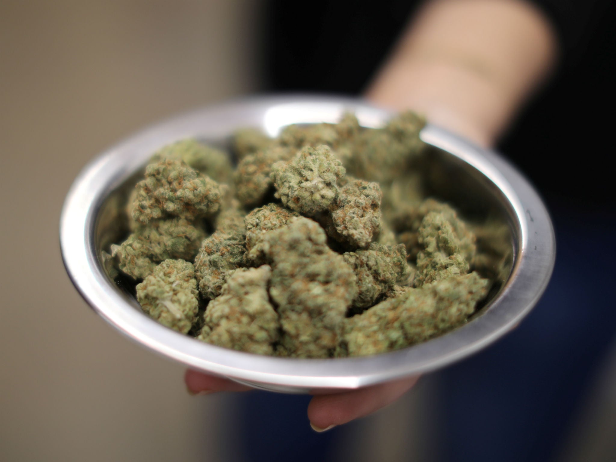 A woman holds marijuana for sale at a store in West Hollywood, California