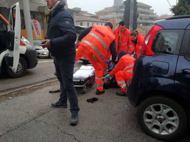 Paramedics treat an injured person that was shot from a passing vehicle in Macerata