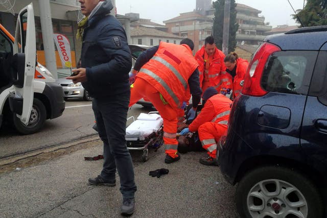 Paramedics treat an injured person that was shot from a passing vehicle in Macerata