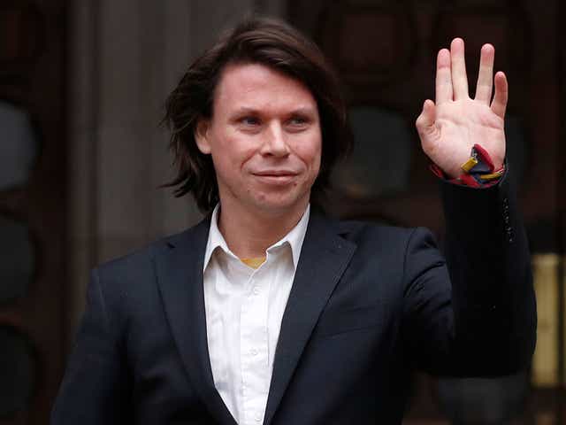 Lauri Love waves to supporters outside The Royal Courts of Justice in London on 5 February