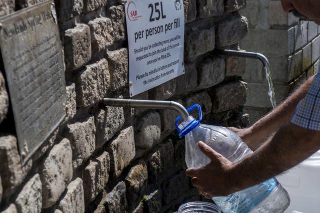 People are queuing to collect water from a natural spring outlet in the South African Breweries in Cape Town, while tourists are being asked to flush the toilet as little as possible