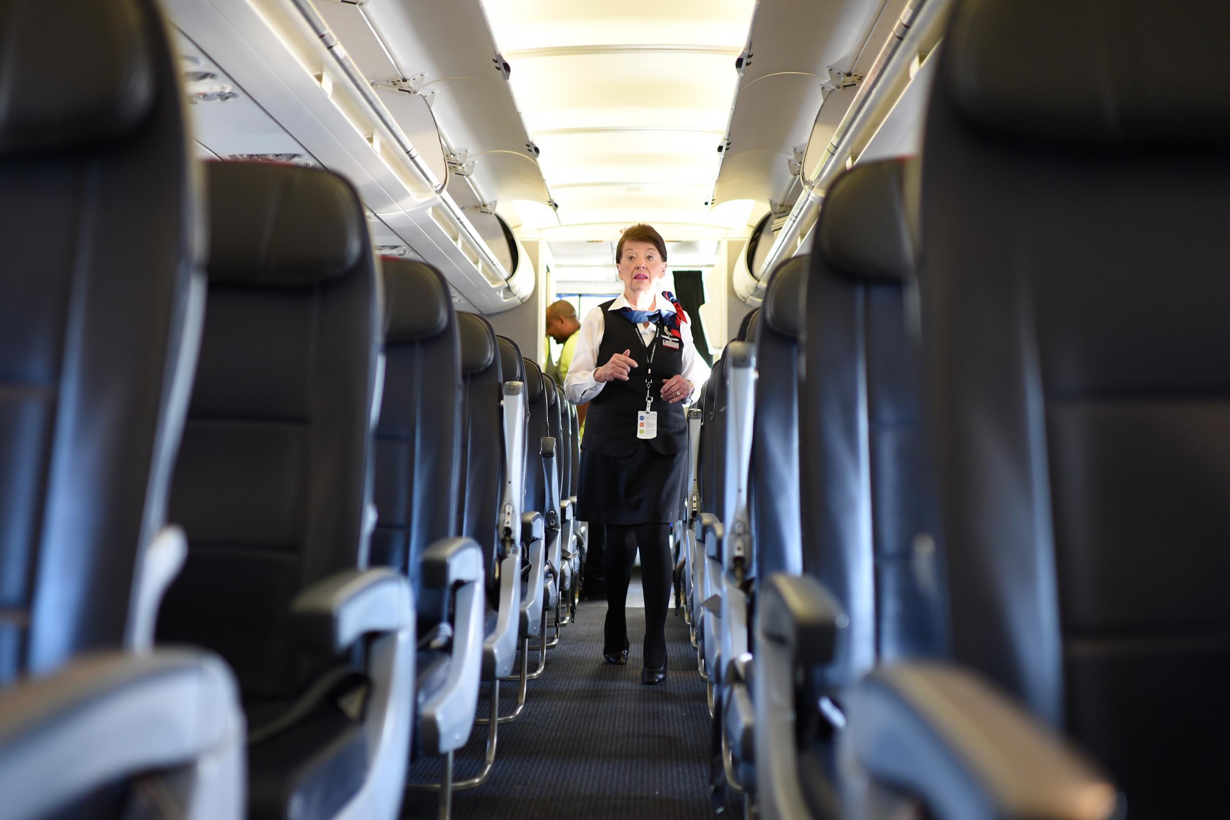 A flight attendant checks on passengers on an unrelated flight