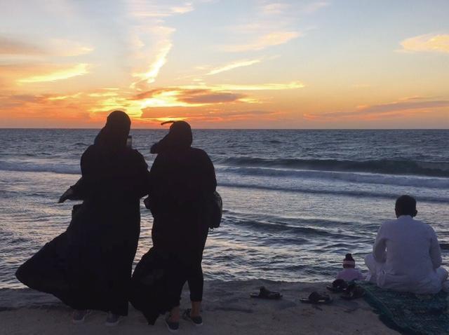 Teenage girls gaze at the sun setting on Jeddah's newly restored Corniche