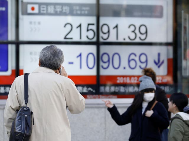People look at an electronic board showing Japan's Nikkei average outside a brokerage in Tokyo, Japan, 6 February, 2018