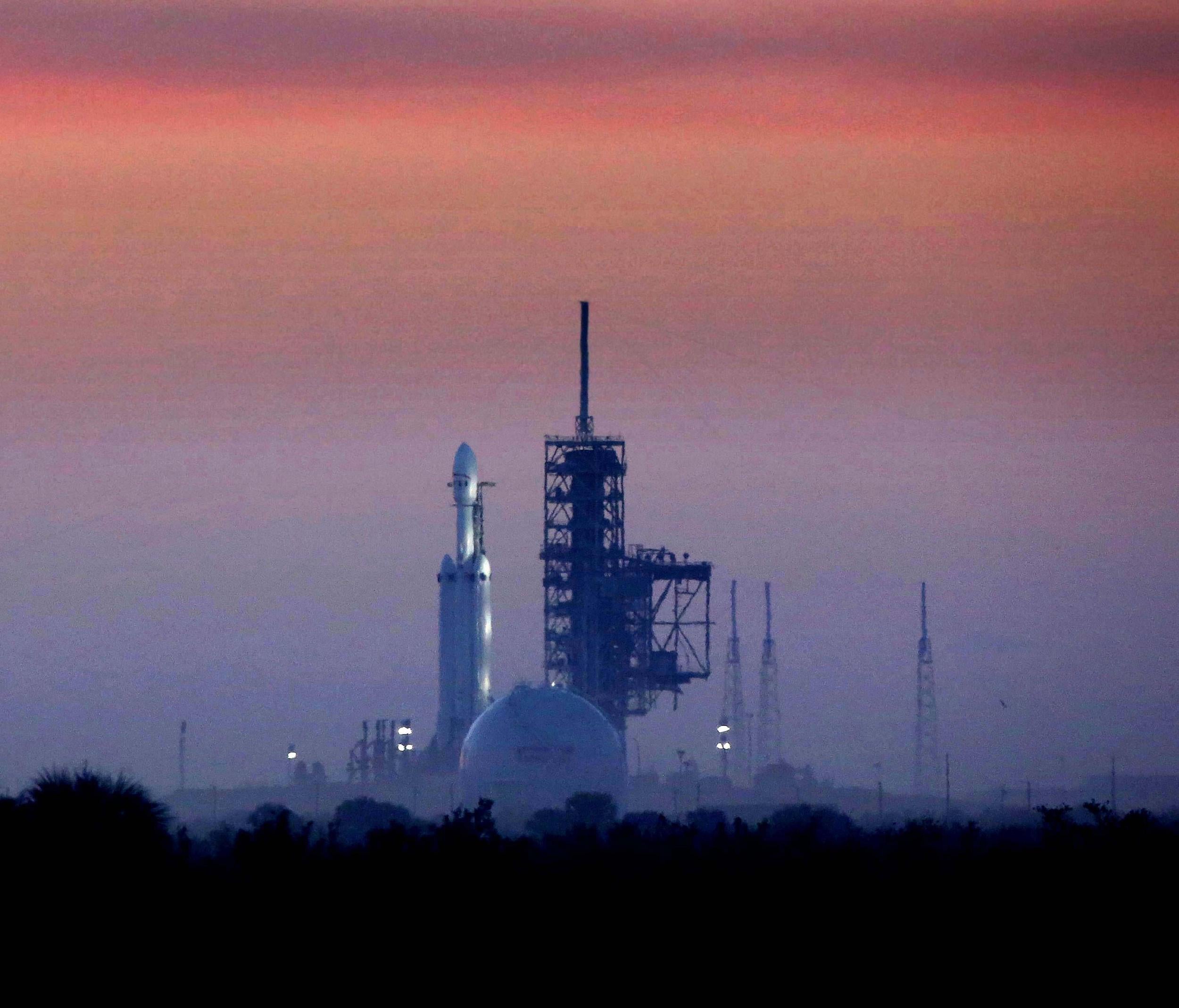 Enveloped in morning fog, the SpaceX Falcon Heavy sits on launchpad 39A at first light, in this view from Playalinda Beach, Florida