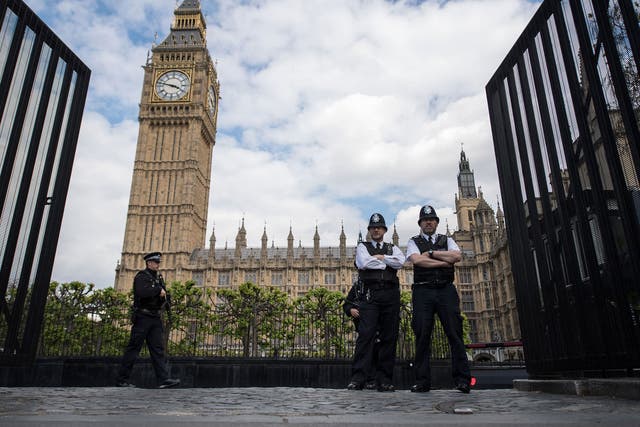 Armed police officers stand guard outside the Houses of Parliament