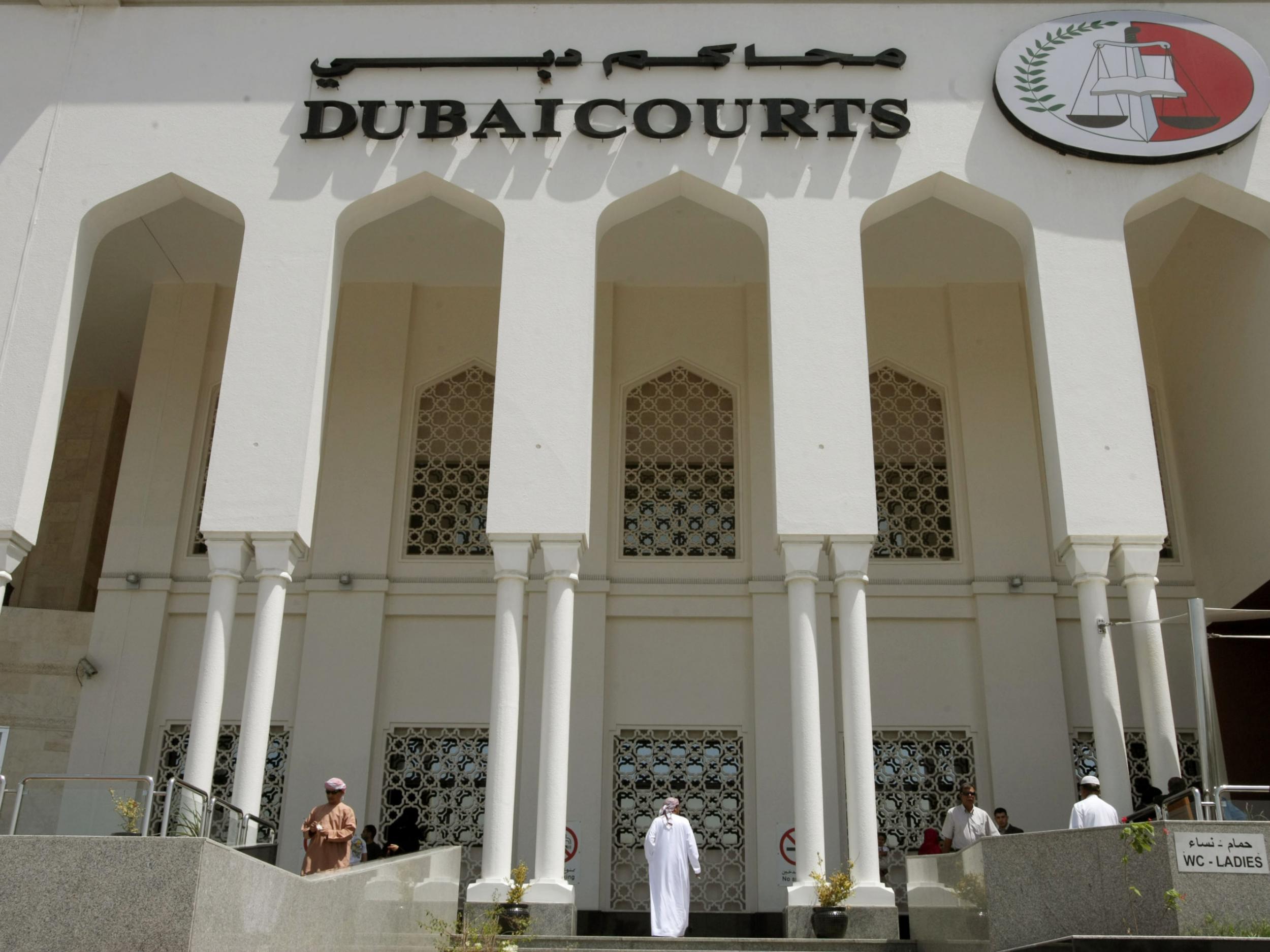 A closeup shot shows the facade of the Dubai Courts building