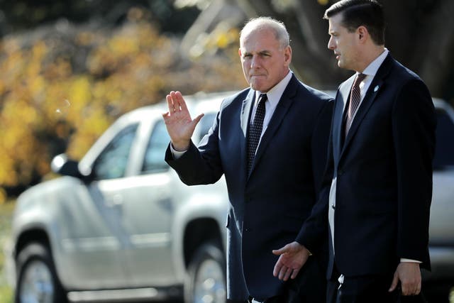 White House Chief of Staff John Kelly (L) waves to journalists as he and Staff Secretary Rob Porter leave the White House