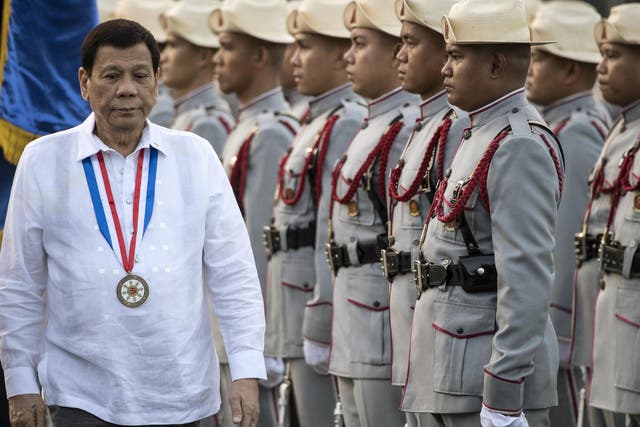 Philippines' President Rodrigo Duterte inspects the honour guards in Manila on 30 December 2017.