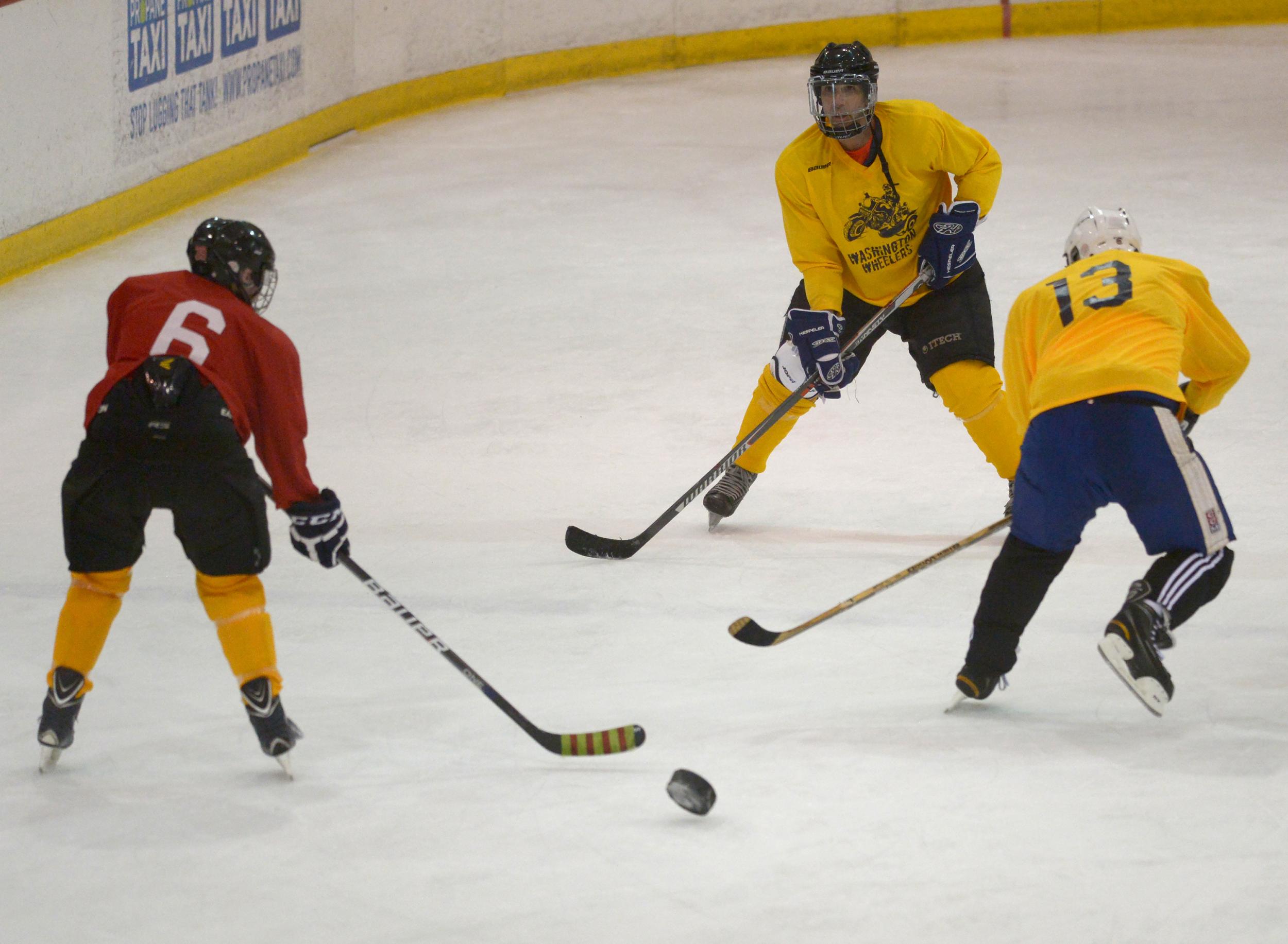 Erin Dawkins, left, scrimmages with Kevin Brown, centre, and John Guzik