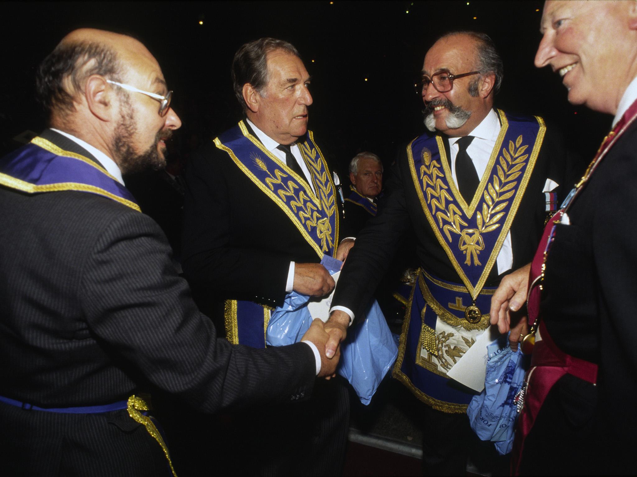 Freemasons greet each other by handshakes at an event in London to promote their craft and public understanding