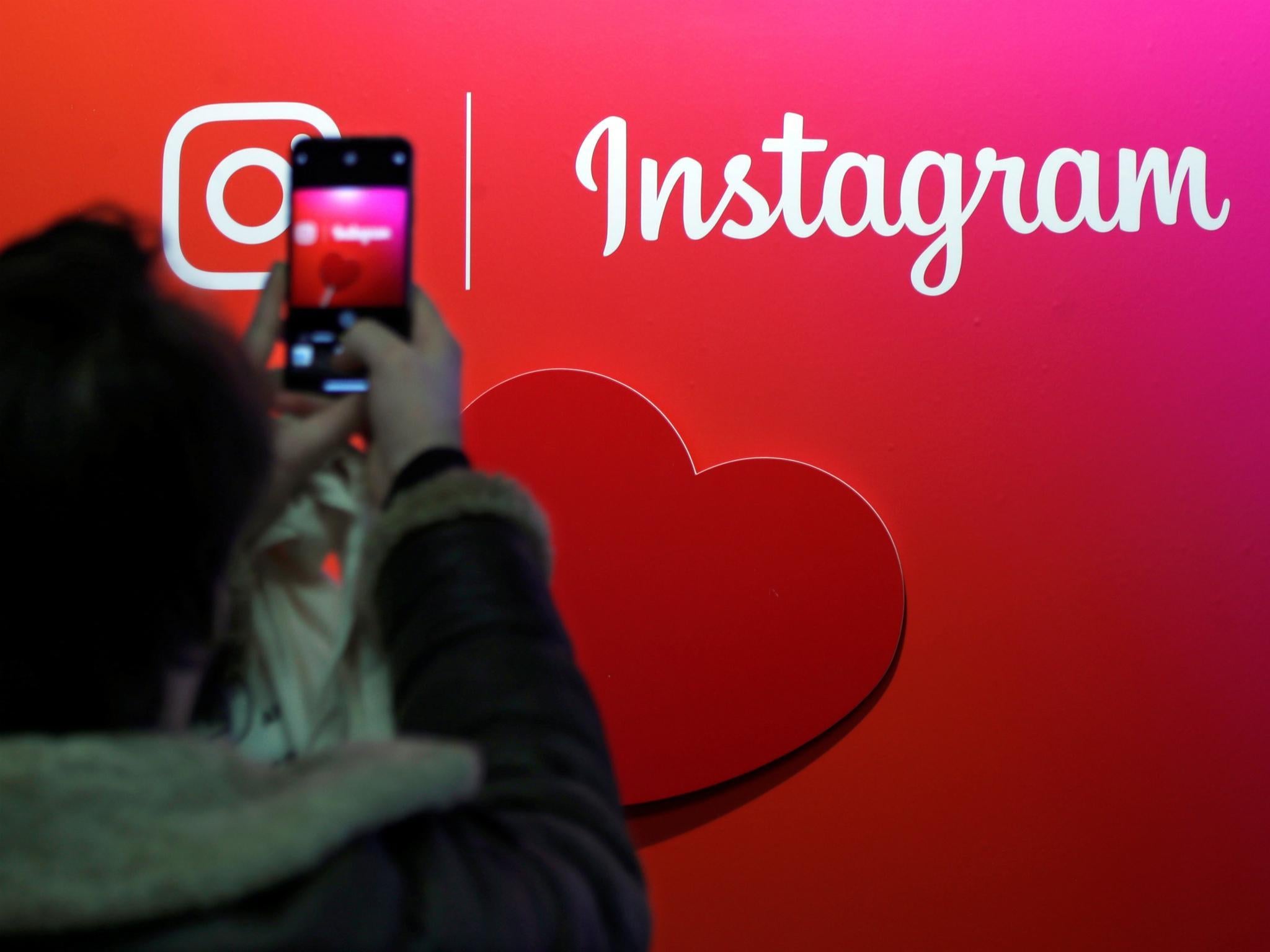 A visitor takes a picture of the Instagram application logo at the Young Entrepreneurs fair in Paris, France, February 7, 2018