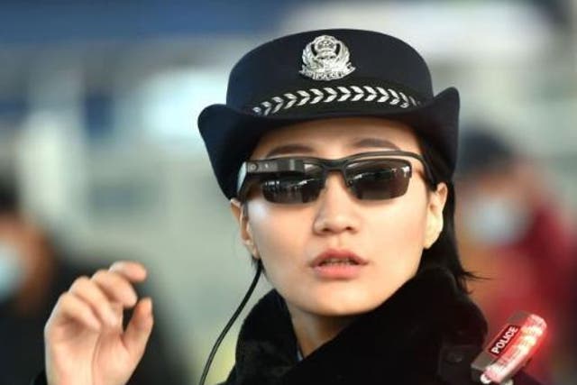 This photo taken on 5 February 2018 shows a police officer wearing a pair of smart glasses with a facial recognition system at Zhengzhou East Railway Station in Zhengzhou in China's central Henan province