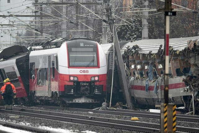 Rescuers at the site where two passenger trains collided in Niklasdorf, central Austria.