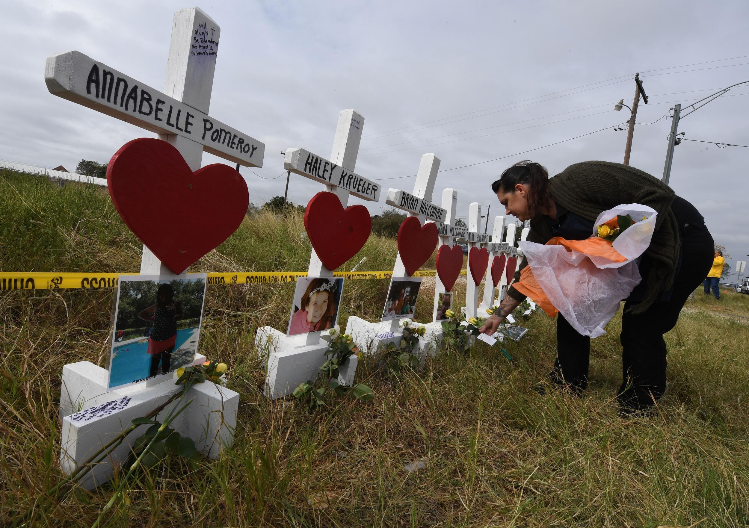 Jessica Mires leaves flowers on crosses named for the victims outside the First Baptist Church, where a mass shooting that killed 26 people