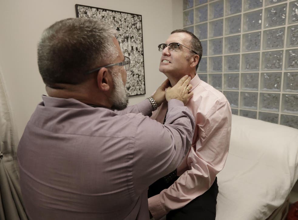 Matt Chappell, right, is checked by Dr Christopher Schiessl during an appointment at a medical center in San Francisco. For more than a decade, the strongest AIDS drugs could not fully control Chappell's HIV infection. Now his body does it by itself, thanks to the first gene editing experiments in people
