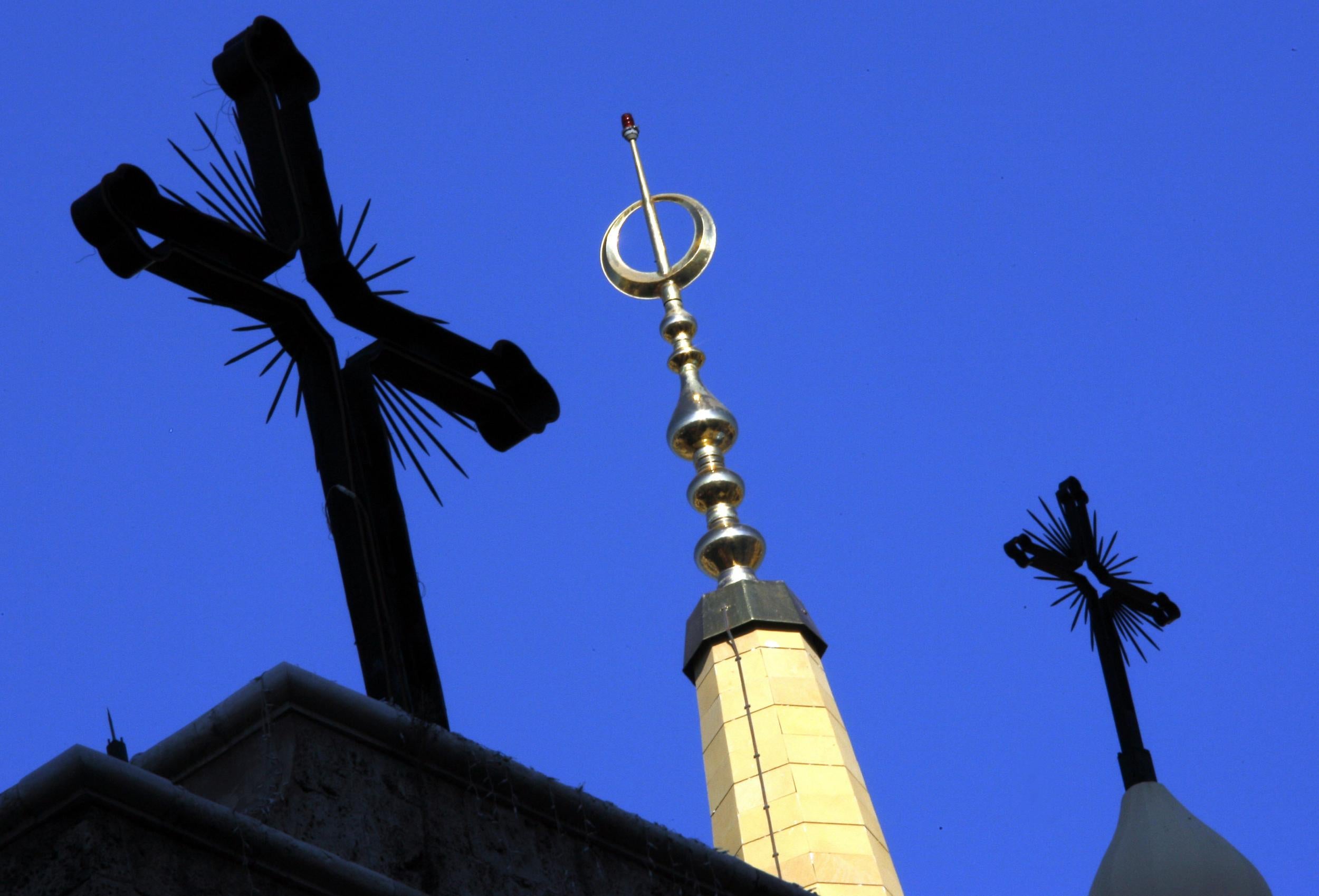 The Christian crosses of the St George orthodox cathedral surround a minaret of al Amin mosque in central Beirut