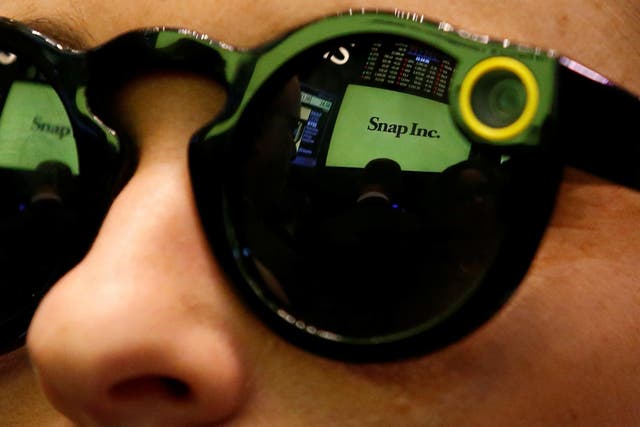 A woman wears Snapchat Spectacles on the floor of the New York Stock Exchange (NYSE) while waiting for Snap Inc. to list their IPO in New York, U.S., March 2, 2017