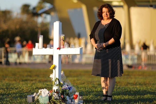 Diana Haneski stands next to a cross erected for the victims of the school shooting in Parkland, Florida