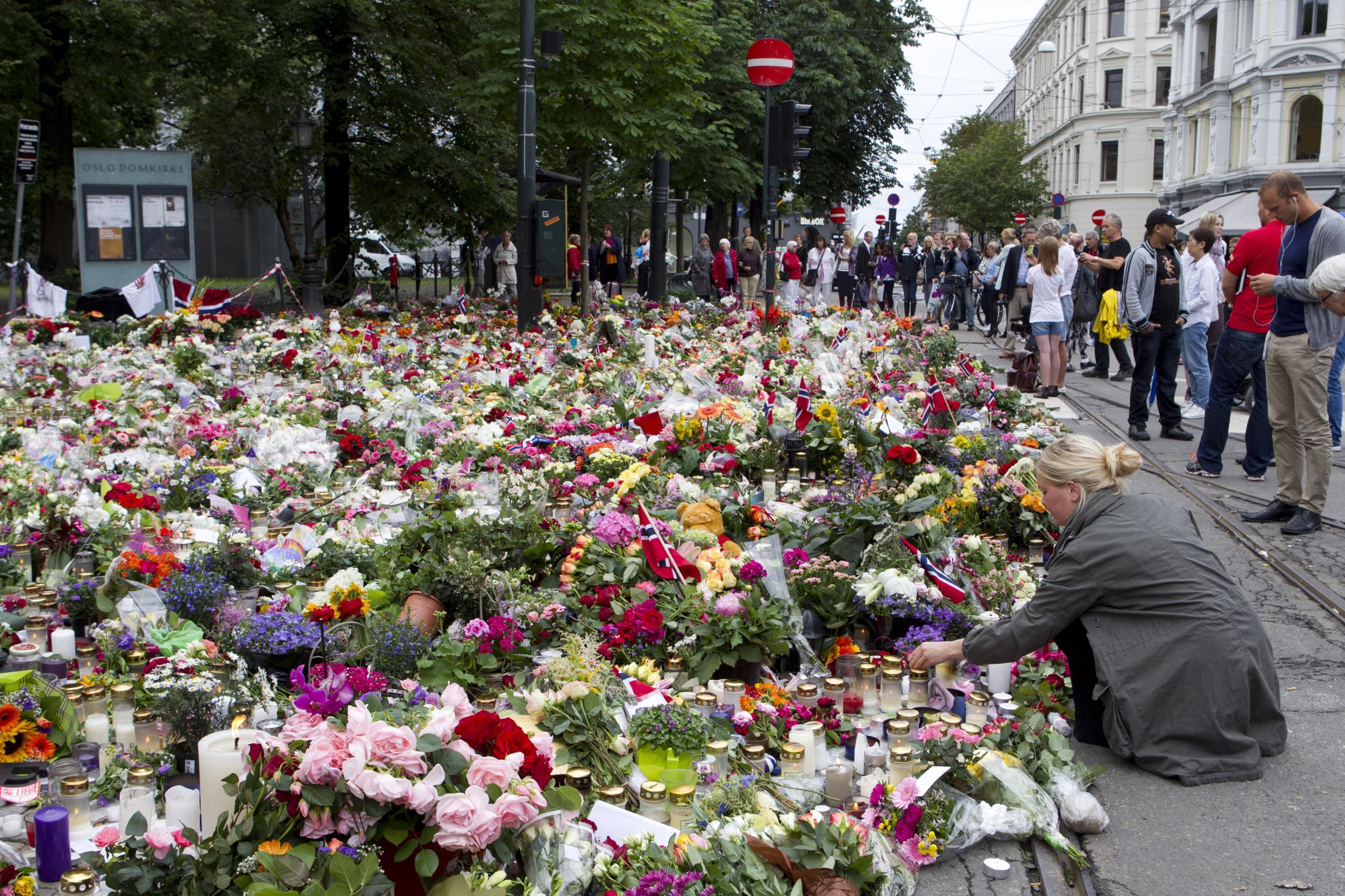 People place flowers in tribute to the victims of the bomb blast and shooting massacre, (Reuters )