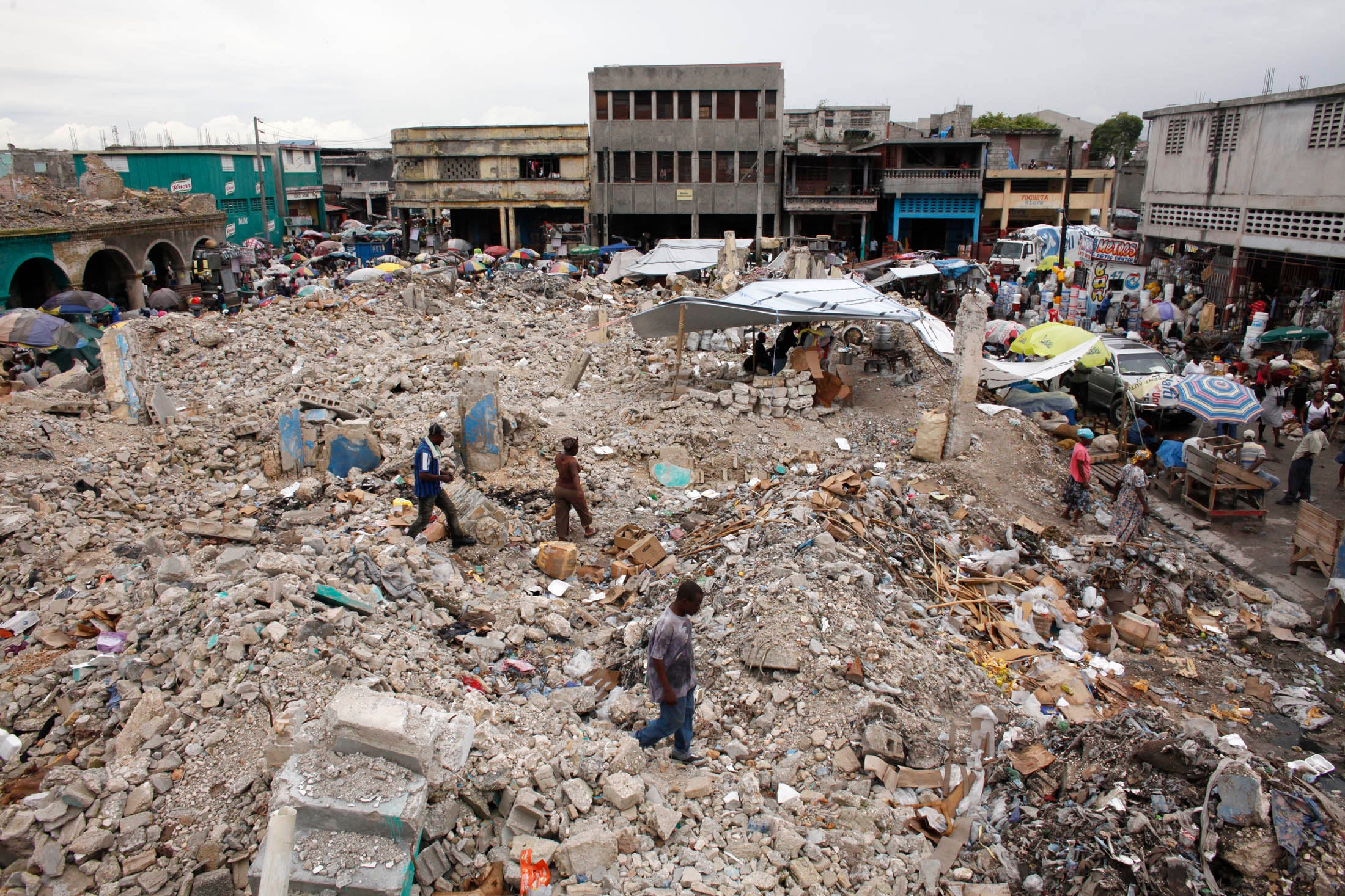 Residents walk over debris of buildings destroyed after an earthquake in downtown Port-au-Prince in 2010