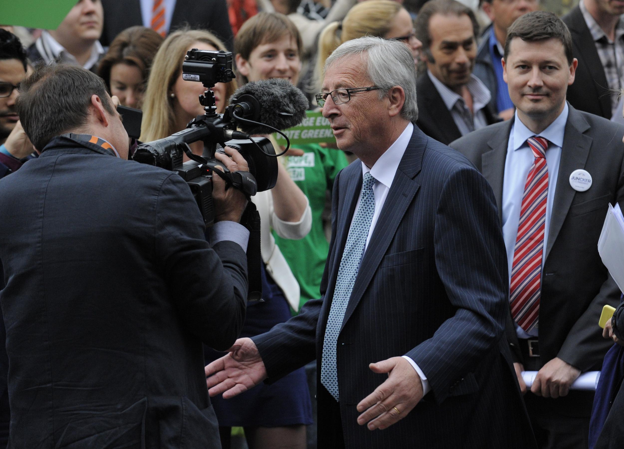 Martin Selmayr (right) stands off camera as Jean-Claude Juncker speaks to journalists
