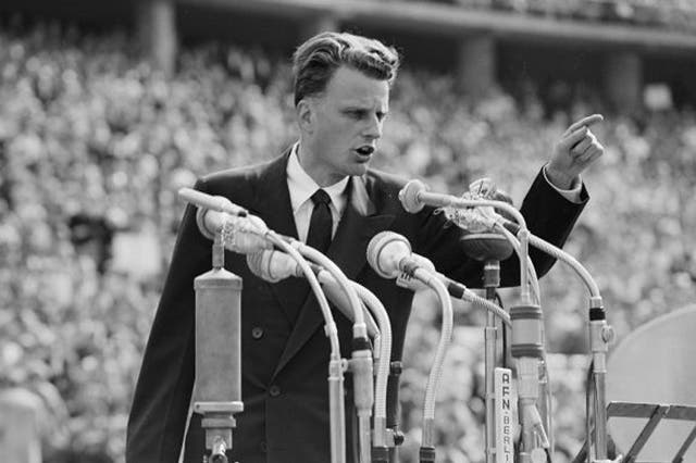 In this June 27, 1954 file photo, Evangelist Billy Graham speaks to over 100,000 people at the Olympic Stadium in Berlin, Germany