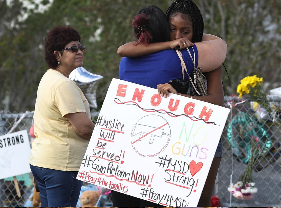 Tyra Heman, a senior at Marjory Stoneman Douglas High School, holds a sign that reads, 'Enough No Guns,' on 19 February 2018 in Parkland, Florida.