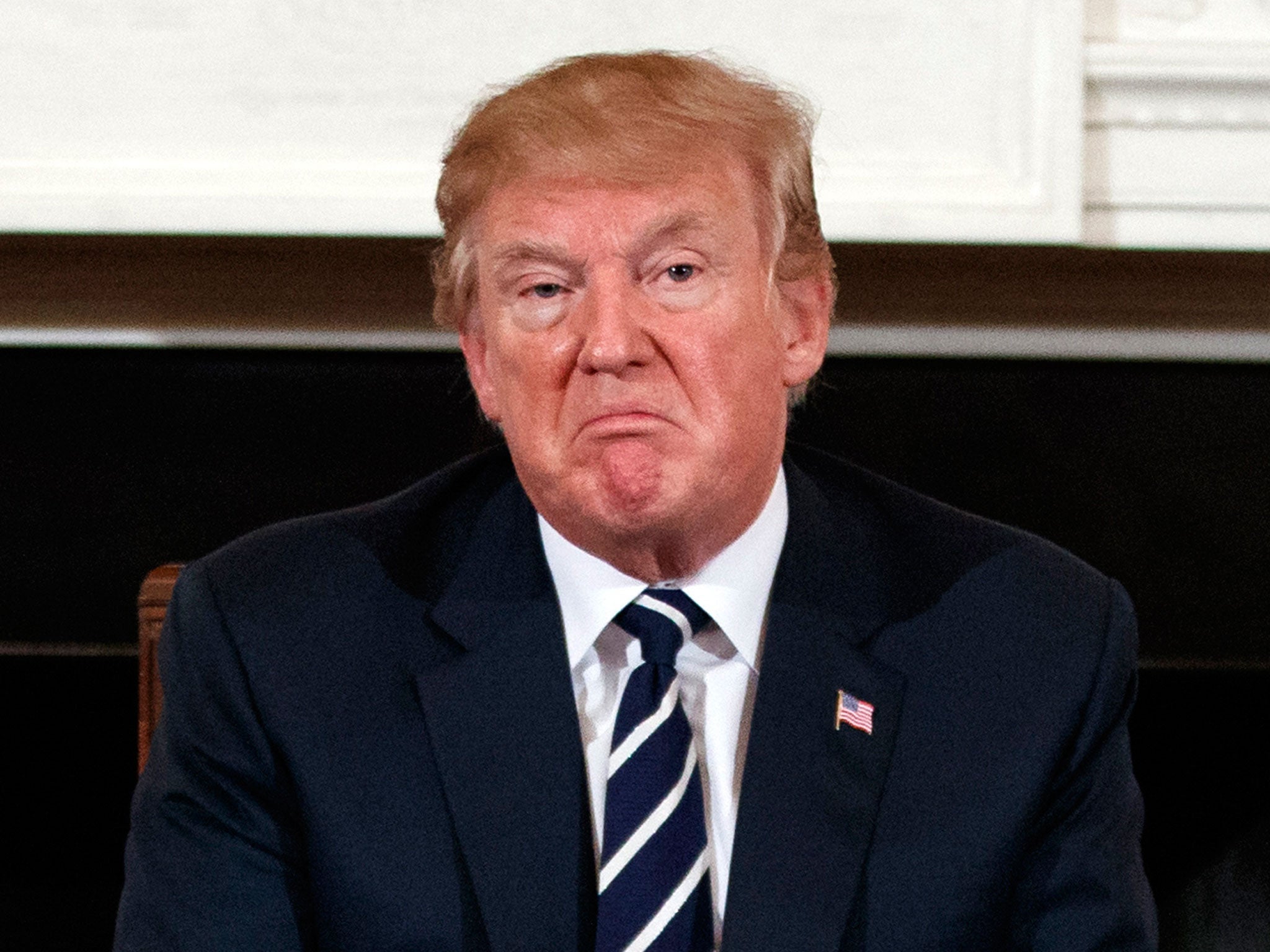 Donald Trump pauses during a listening session with high school students, teachers and others in the State Dining Room of the White House