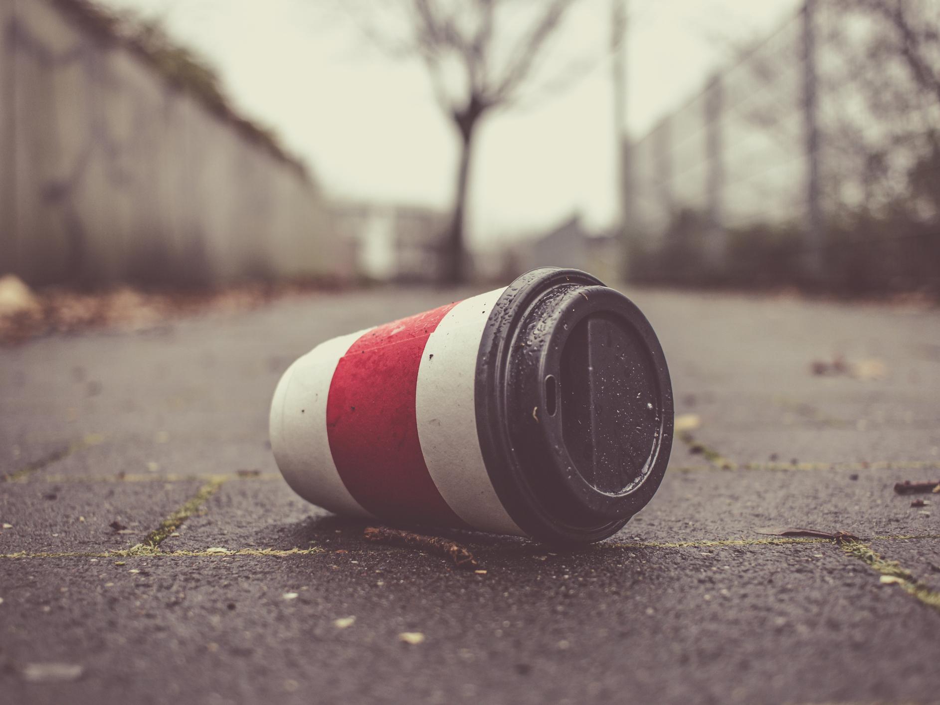 Used coffee cup on a pavement