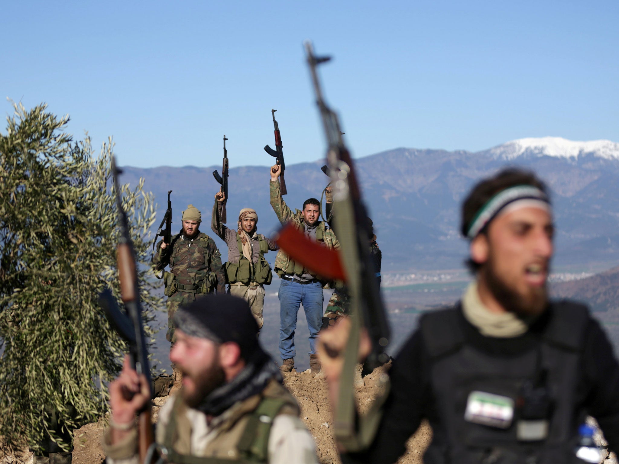 Turkish-backed Free Syrian Army fighters brandish their weapons near the city of Afrin