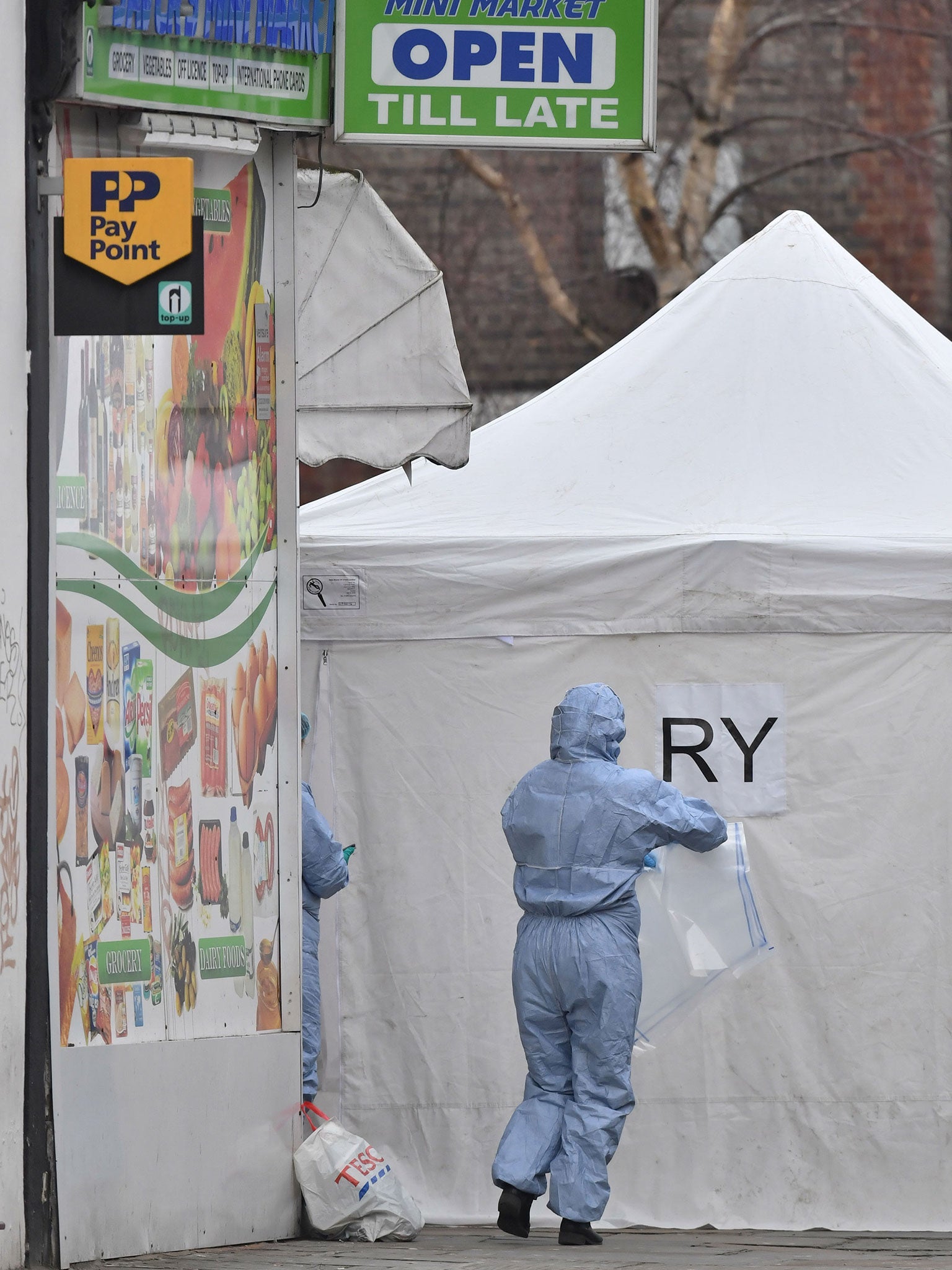 Police forensics officers at the scene in Bartholomew Road, Camden, London, after a young man was fatally stabbed.