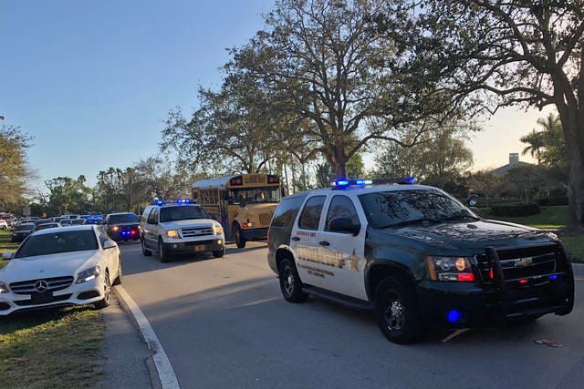 Police and security vehicles are seen at Marjory Stoneman Douglas High School in Parkland, Florida, following a school shooting