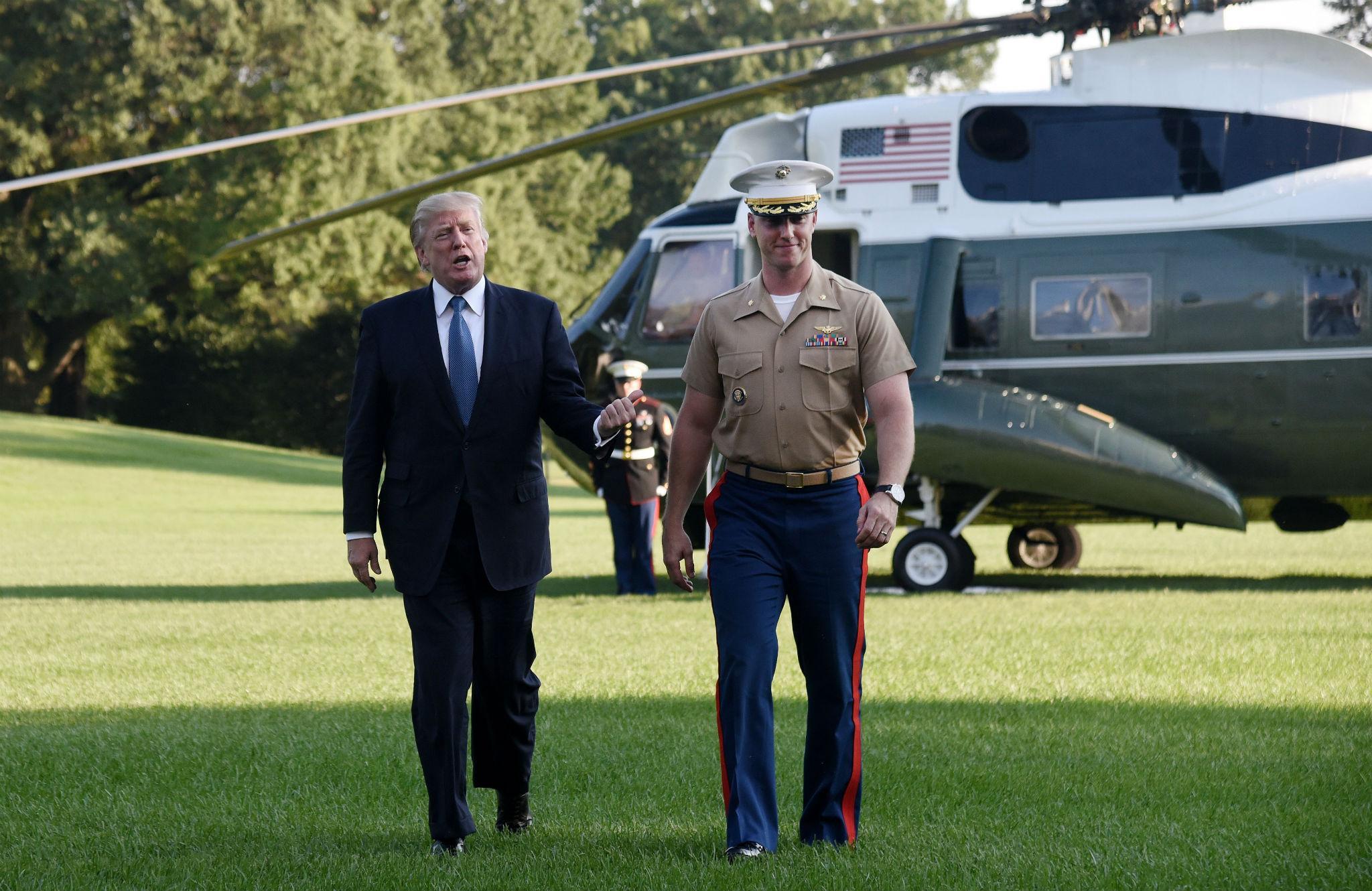 President Donald Trump walks toward the White House with Marine One pilot James Thompson Jr.