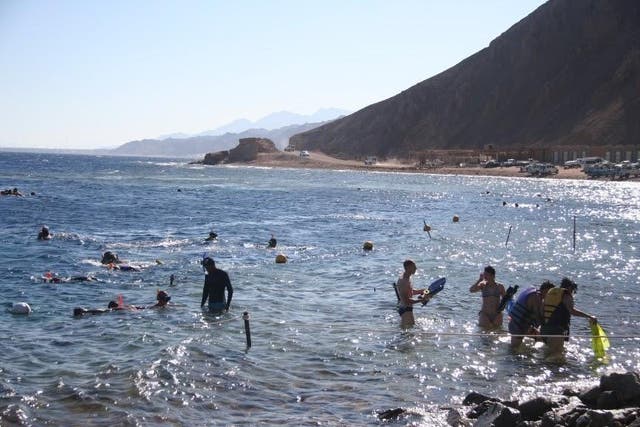 Swimmers beside the Red Sea shoreline in Dahab