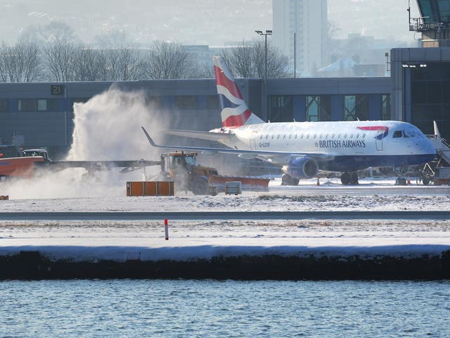 A British Airways passenger plane gets de-iced at London City airport in sub-zero temperatures after an overnight snow storm caused travel chaos across the capital