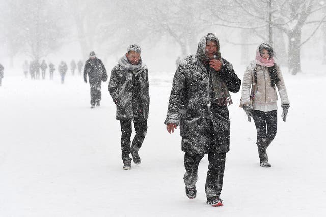 People walk through heavy snow in Green Park in central London 
