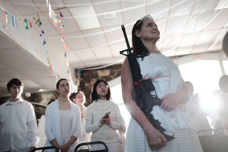A woman holds an AR-15 rifle during a ceremony at the World Peace and Unification Sanctuary in Newfoundland, Pennsylvania