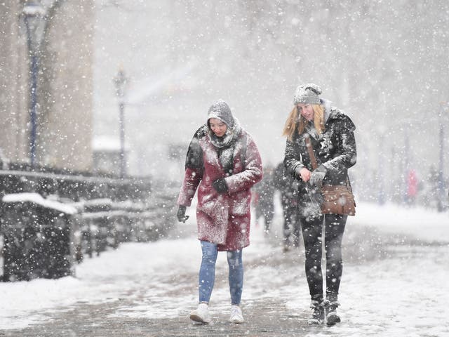 People walking in the snow by Tower Bridge in London, as the highest level of weather warning has been issued for parts of England and Wales