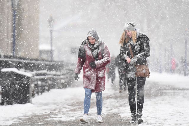 People walking in the snow by Tower Bridge in London, as the highest level of weather warning has been issued for parts of England and Wales