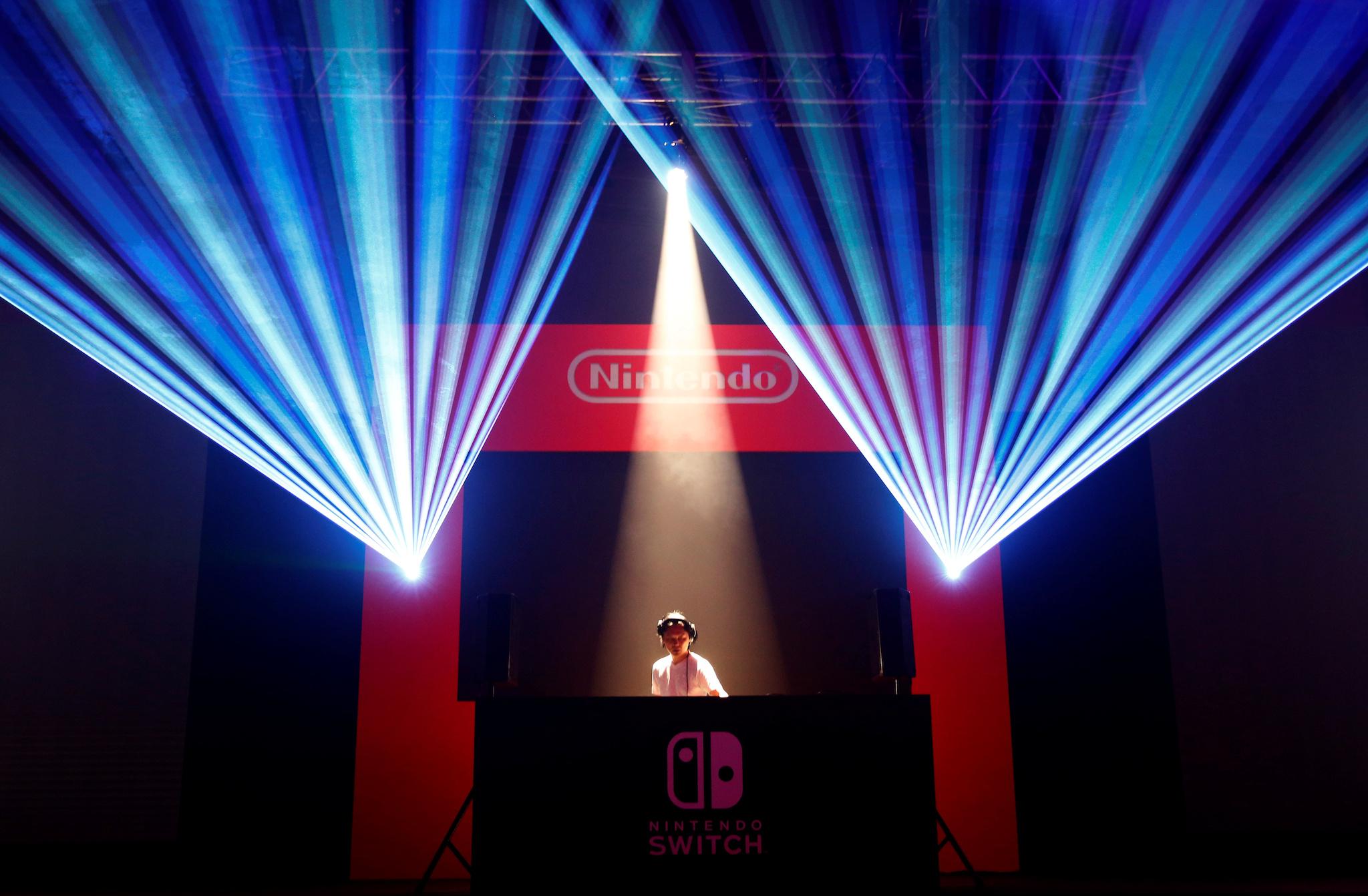 A DJ performs in front of Nintendo's logo at the presentation ceremony of its new game console Switch in Tokyo, Japan January 13, 2017