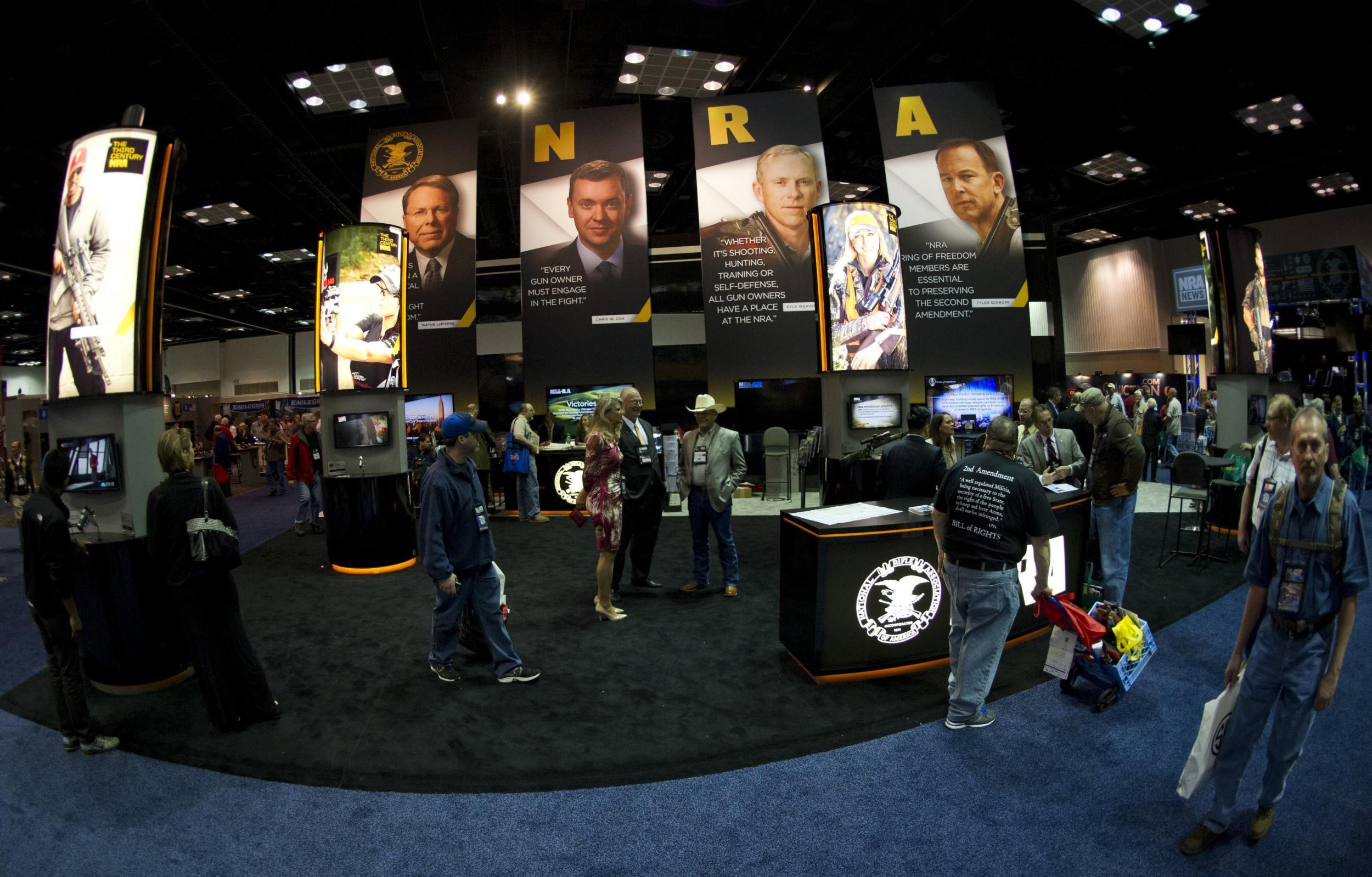 Convention goers walk through the NRA booth at the143rd NRA Annual Meetings and Exhibits at the Indiana Convention Center