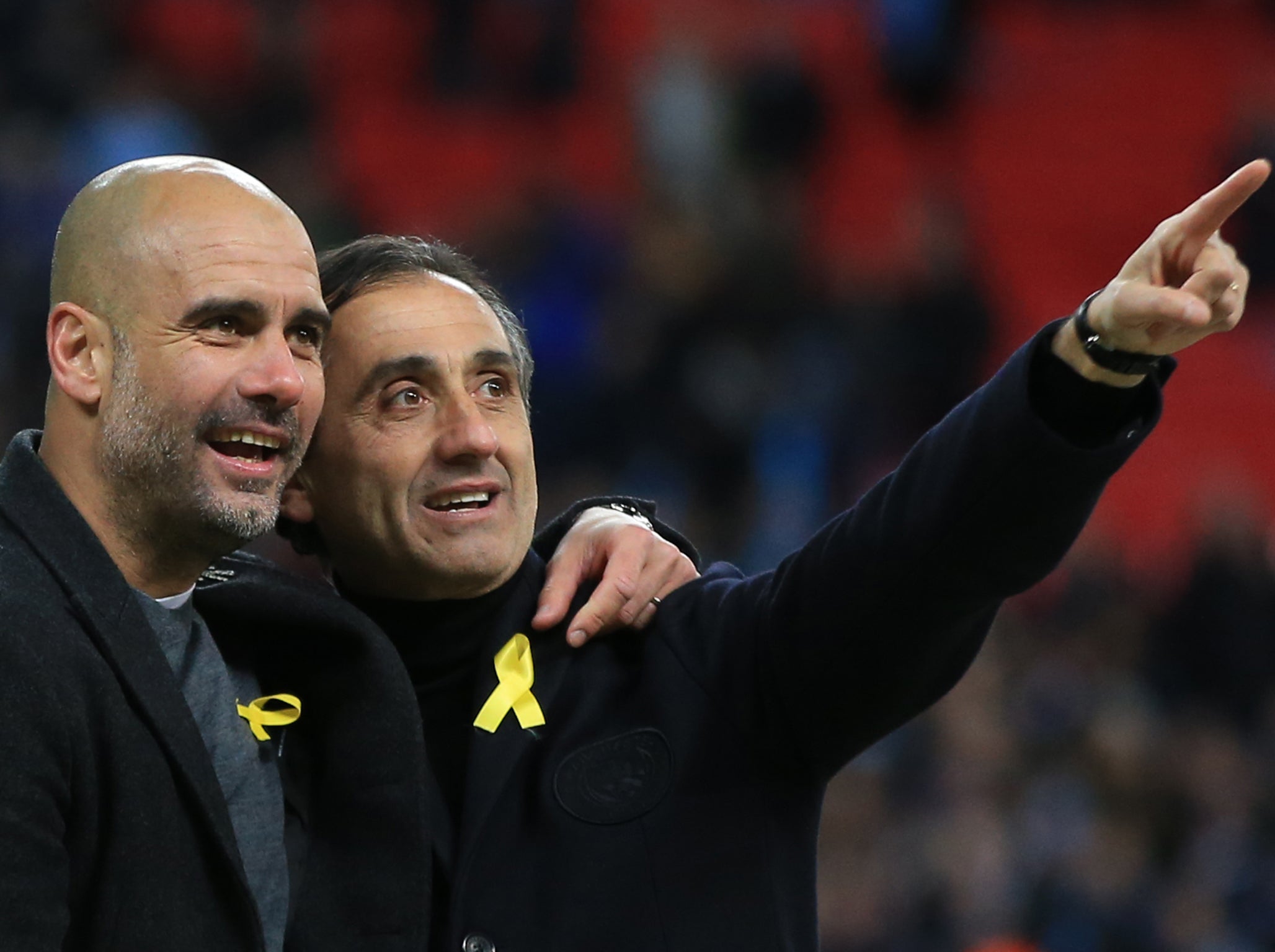 Pep Guardiola and assistant Manuel Estiarte, wearing their pro Catalan ribbons