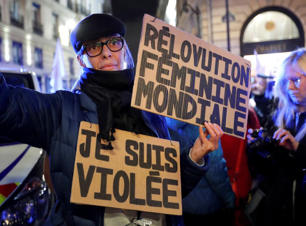 A feminist activist holds placards near the Justice ministry during a protest calling to change French statutory rape laws